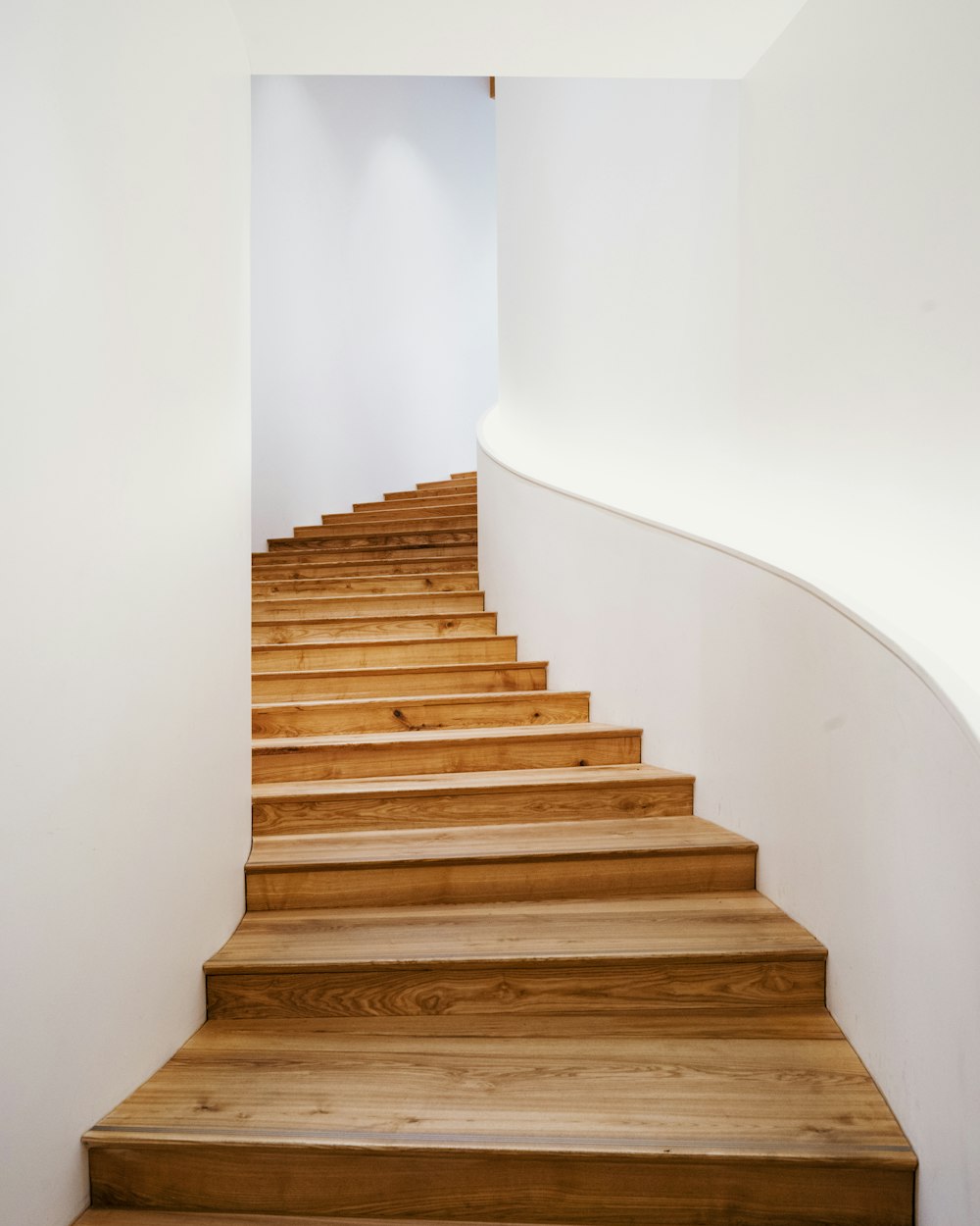Massive Holztreppe an heller Wand, sauber und klar.